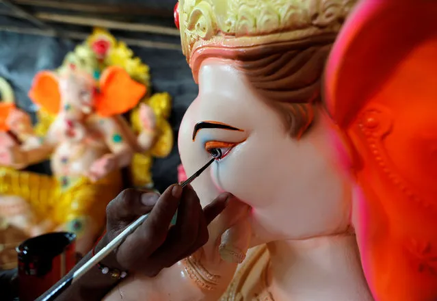 An artisan paints an idol of Hindu god Ganesh, the deity of prosperity, at a workshop ahead of the Ganesh Chaturthi festival celebrations, in Ahmedabad, India, August 29, 2016. (Photo by Amit Dave/Reuters)
