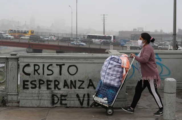A street vendor passes graffiti that reads in Spanish: “Christ, hope for life” in Lima, Peru, Thursday, July 23, 2020, amid the COVID-19 pandemic. (Photo by Martin Mejia/AP Photo)