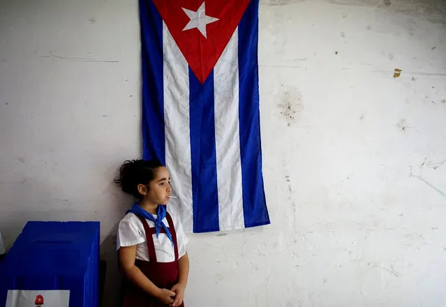 Sofia Ema, 8, waits for voters at a polling station in Havana, Cuba on November 26, 2017. (Photo by Alexandre Meneghini/Reuters)