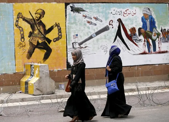 Women walk past graffiti painted by pro-Houthi activists on the wall of the Saudi embassy in Yemen's capital Sanaa August 18, 2015. The writing reads, “We will not bow down but to Allah”. (Photo by Khaled Abdullah/Reuters