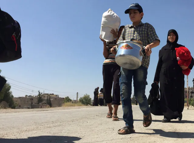 Civilians carry their belongings while walking to be evacuated, after reports of an agreement between rebels and Syria's army to evacuate civilians and rebel fighters from Moadamiya, in Damascus, Syria September 2, 2016. (Photo by Omar Sanadiki/Reuters)