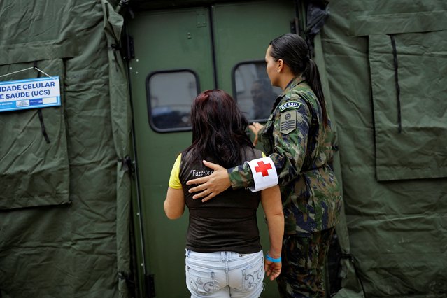 A patient is escorted while waiting to receive medical attention in a makeshift tent to treat suspected dengue cases, in the administrative region of Ceilandia, on the outskirts of Brasilia, Brazil on February 5, 2024. (Photo by Ueslei Marcelino/Reuters)