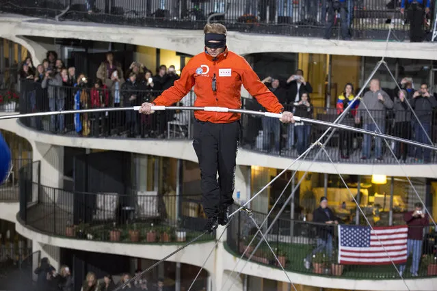 This photo provided by Discovery Communication shows Nik Wallenda walking across the Chicago skyline blindfolded for Discovery Channel's Skyscraper Live with Nik Wallenda on Sunday, November 2, 2014. (Photo by Jean-Marc Giboux/AP Photo/Discovery Communication)