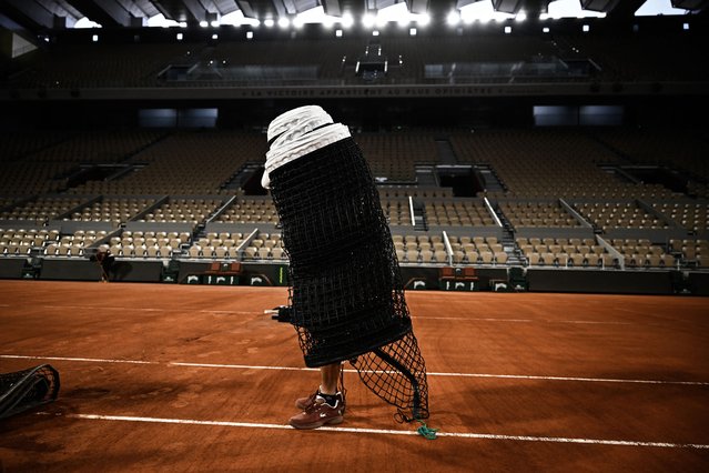 A staff member prepares to arrange the net on the Court Philippe-Chatrier, ahead of French Open 2025 at the Roland Garros Complex, in Paris on May 21, 2025. (Photo by Julien de Rosa/AFP Photo)