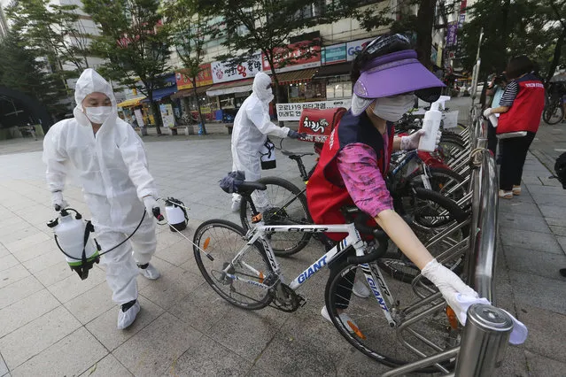 Workers and volunteers disinfect as a precaution against the coronavirus on a street in Goyang, South Korea, Tuesday, August 25, 2020. South Korea is closing schools and switching back to remote learning in the greater capital area as the country counted its 12th straight day of triple-digit daily increases in coronavirus cases. (Photo by Ahn Young-joon/AP Photo)