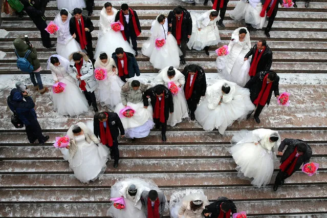 Chinese newlywed couples walk together during a collective wedding ceremony at the 34th Harbin International Ice and Snow Festival in Harbin, China's northeastern Heilongjiang province, 08 January 2018. As many as 34 couples from Beijing and China's 13 provinces participated in this collective wedding ceremony, which is part of the Harbin international ice and snow festival events. (Photo by Wu Hong/EPA/EFE)