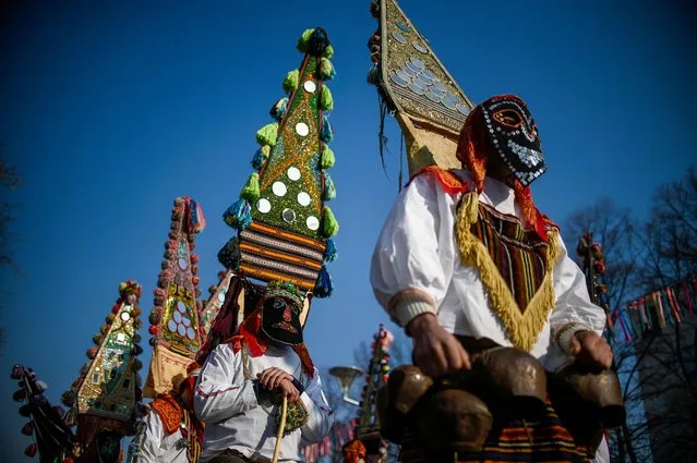  Dancers, known as “Kukeri”, perform on January 28, 2018 during the International Festival of the Masquerade Games in Pernik, near Sofia, Bulgaria. The three-day festival, which started on January 26, has participants sporting multi-colored masks, covered with beads, ribbons and woolen tassels while the main dancer, ladened with bells to drive away sickness and evil spirits, sways like a wheat spikelet heavy with grain. (Photo by Nikolay Doychinov/AFP Photo)