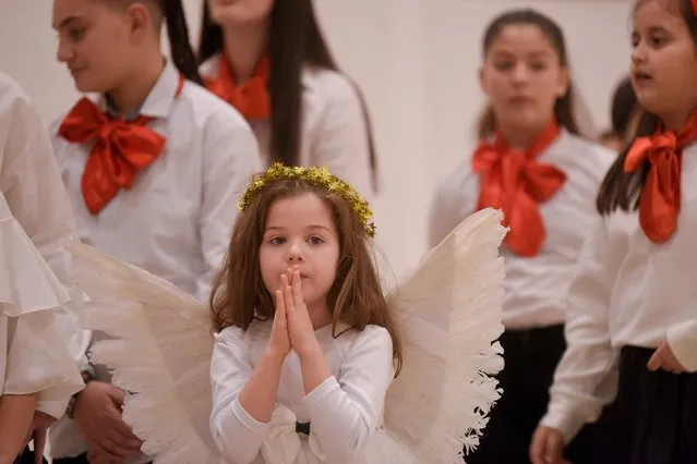 A Kosovar child dressed as an angel attends the Christmas eve mass, marking the birth of Jesus Christ, at the Mother Teresa Cathedral in Pristina on December 24, 2022. (Photo by Armend Nimani/AFP Photo)