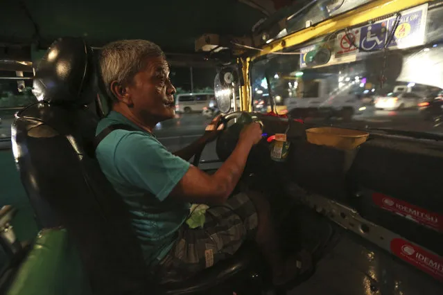 In this September 26, 2017, photo, Filipino driver Victorino Samson, 62, drives his jeepney in Manila, Philippines. Samson has supported his family with his earnings as a jeepney driver for 30 years. (Photo by Aaron Favila/AP Photo)