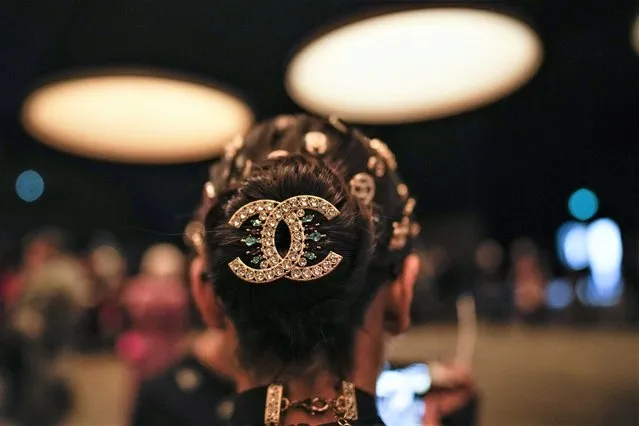An audience member with a Chanel logo hair clip arrives at the Chanel Haute Couture Spring-Summer 2023 collection presented in Paris, Tuesday, January 24, 2023. (Photo by Christophe Ena/AP Photo)