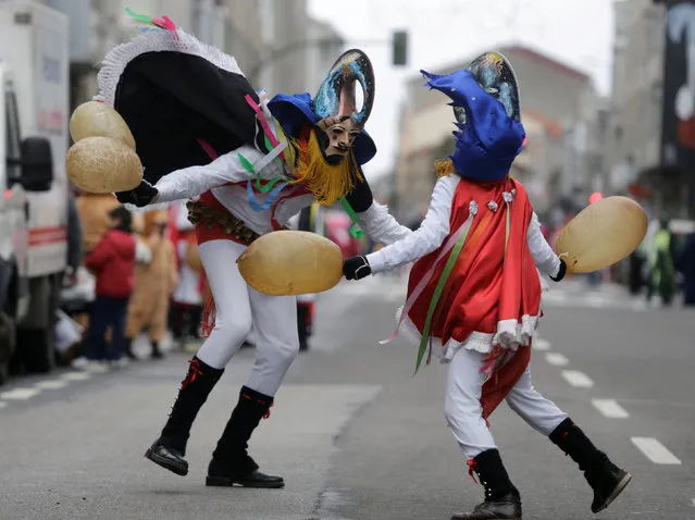 Revellers strike each other with pig bladders on a street during carnival celebrations in the northwestern village of Xinzo de Limia, Spain February 13, 2018. The revellers are dressed as “Pantalla”, in reference to ancient tax collectors, and pursues villagers through the streets ringing cowbells and striking them with pig bladders. (Photo by Miguel Vidal/Reuters)