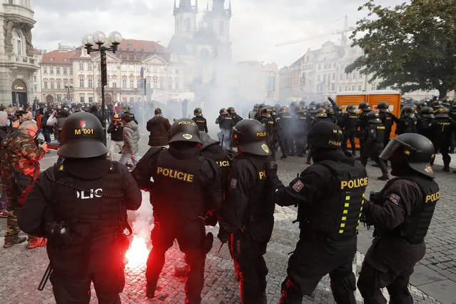 Police confront demonstrators as they protest against the COVID-19 restrictive measures at Old Town Square in Prague, Czech Republic, Sunday, October 18, 2020. (Photo by Petr David Josek/AP Photo)