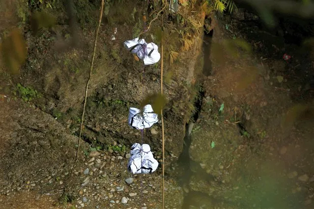 A rescue team recovers the bodies of victims from the site of the plane crash of a Yeti Airlines-operated aircraft, in Pokhara, Nepal on January 17, 2023. The Yeti Airlines flight with 68 passengers and four crew plummeted into a steep gorge, smashed into pieces and burst into flames as it approached the central city of Pokhara on January 15, in Nepal's worst aviation disaster since 1992. (Photo by Sulav Shrestha/Reuters)