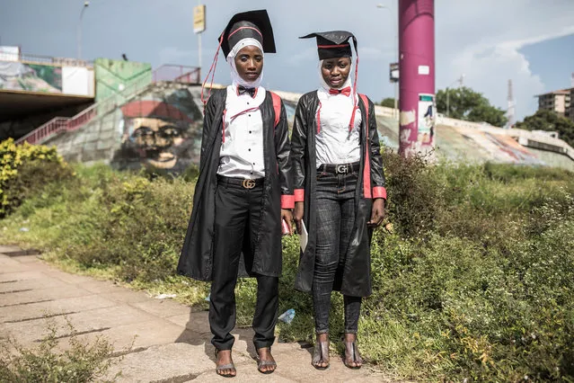 Two young women pose for a portrait, dressed in robes after collecting their Bachelor degrees in Conakry on October 12, 2020. Presidential elections are to be held on October 18, with incumbent President bidding for a third term in office, defying critics who say he forced through a new constitution this year enabling him to sidestep two-term presidential limits. (Photo by John Wessels/AFP Photo)