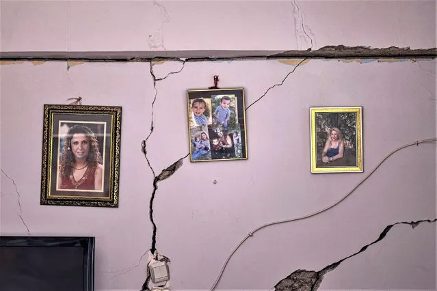 This photograph taken on February 21, 2023, shows cracks running up a wall on which family photographs are hanging, after a 6.4-magnitude quake hit the Hatay province in southern Turkey, in Antakya. The 6.4-magnitude earthquake struck on February 20, two weeks after a 7.8-magnitude earthquake hit near Gaziantep, Turkey, in the early hours of February 6, followed by another 7.5-magnitude tremor just after midday. The initial quakes caused widespread destruction in southern Turkey and northern Syria and has killed more than 44,000 people. (Photo by Sameer Al-Doumy/AFP Photo)