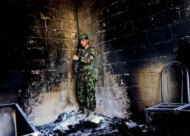 An Afghan army soldier stands guard in the destroyed courthouse in Farah, Afghanistan, on April 4, 2013. Thursday Suicide bombers disguised as Afghan soldiers stormed the building in a failed bid to free more than a dozen Taliban prisoners.Tens of people, including the nine attackers were reported killed in the fighting. (Photo by Hoshang Hashimi/Associated Press)