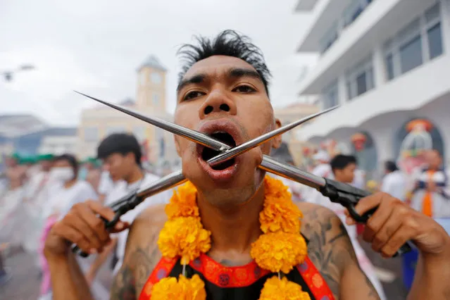 A devotee of the Chinese Bang Neow shrine, with his cheeks piercied, takes part in a procession celebrating the annual vegetarian festival in Phuket, Thailand, October 6, 2016. (Photo by Jorge Silva/Reuters)