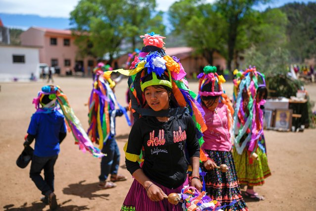 Raramuri Indigenous youth dance during a sacred Yumari ceremony to ask for rain and good crops and to honor two local Jesuit priests, Javier Campos and Joaquin Mora, who were murdered in 2022 by a gang leader, in Cuiteco, Mexico, Saturday, May 11, 2024. Among the inhabitants of the Tarahumara mountains, especially among the Indigenous Raramuri people, priests are often regarded as profoundly beloved figures who fearlessly offer comfort and help. (Photo by Eduardo Verdugo/AP Photo)