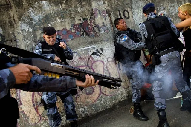 Demonstrators clash with police as another officer fires tear gas at activists protesting the privatization of the Maracana stadium and planned demolition of the indigenous museum located next to the stadium, in Rio de Janeiro, on April 26, 2013. After a series of delays, criticisms and protests, the iconic Maracana will reopen Saturday to host a friendly match between teams put together by former football stars Ronaldo and Bebeto - in a test event ahead of the Confederations Cup in June. (Photo by Silvia Izquierdo/Associated Press)