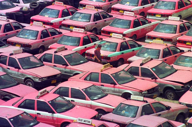 In this October 27, 1997, file photo, a taxi driver walks through hundreds of taxis taken out of service to save operating costs in Bangkok, Thailand. (Photo by Sakchai Lalit/AP Photo)