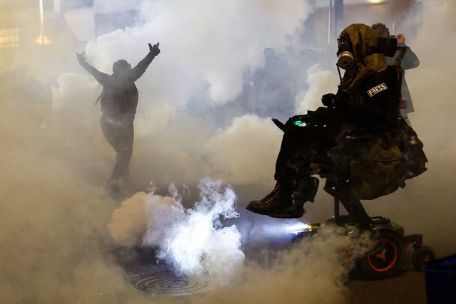 A person gestures amid tear gas as law enforcement officers advance to disperse demonstrators near U.S. Immigration and Customs Enforcement (ICE) headquarters in Portland, Oregon, U.S., October 4, 2025. (Photo by John Rudoff/Reuters)