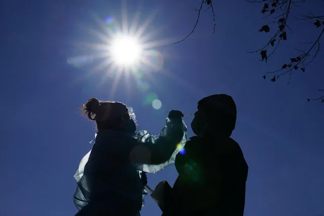 Registered nurse Laura Moore, left, swabs a patient during testing for COVID-19 organized by Philadelphia FIGHT Community Health Centers at Mifflin Square Park, Thursday, December 10, 2020, in south Philadelphia. (Photo by Matt Slocum/AP Photo)