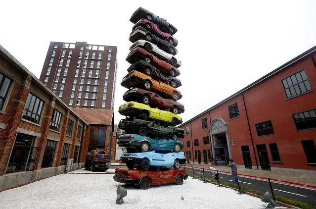 Visitors look at an art form made by piles of colorful scraped cars, entitled “2013 Rebirth”, on display at an art zone renovated from an old factory in Wuhan in central China's Hubei province, on May 10, 2013. (Photo by Associated Press)