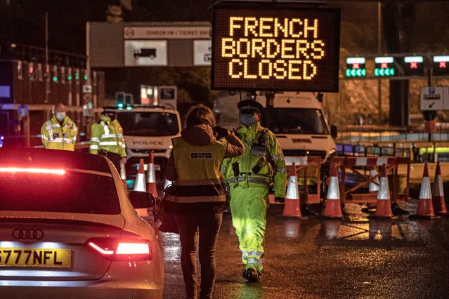 Police and port security staff stop cars and lorries at the entrance to the closed ferry terminal in Dover, England, Monday, December 21, 2020, after the Port of Dover was closed and access to the Eurotunnel terminal suspended following the French government's announcement. France banned all travel from the UK for 48 hours from midnight Sunday, including trucks carrying freight through the tunnel under the English Channel or from the port of Dover on England's south coast. (Photo by Sean Smith/The Guardian)