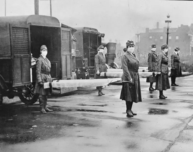 In this October 1918 photo made available by the Library of Congress, St. Louis Red Cross Motor Corps personnel wear masks as they hold stretchers next to ambulances in preparation for victims of the influenza epidemic. A century after one of history’s most catastrophic disease outbreaks, scientists are rethinking how to guard against another super-flu like the 1918 influenza that slaughtered tens of millions as it swept the globe in mere months. (Photo by Library of Congress via AP Photo)