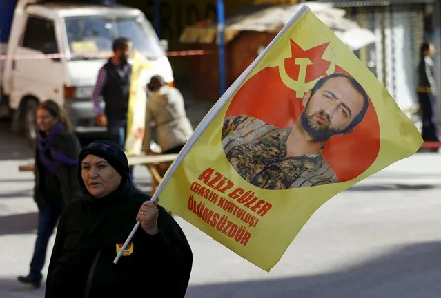 A woman carries a flag with an image of Aziz Guler that reads "Aziz Guler is immortal", during his funeral ceremony in Gazi neighborhood of Istanbul, Turkey, November 22, 2015. According to the local media, left-wing activist Aziz Guler was killed on September 21 in a landmine explosion while he was fighting for the Syrian Kurdish YPG militia against Islamic State militants in northern Syria. (Photo by Murad Sezer/Reuters)