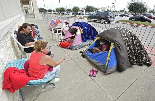 Members of the Vazquez family sit outside their tents along with other people while camping out in tents outside a Best Buy store two days ahead Black Friday shopping in a suburb of Houston, Texas in Rosenberg, Texas, USA, 25 November 2015. Retailers in the United States have looked to the Friday after Thanksgiving, known as Black Friday, as an opportunity to make a large amount of holiday sales, though the tradition in recent years has been pushed into Thanksgiving evening. (Photo by Larry W. Smith/EPA)