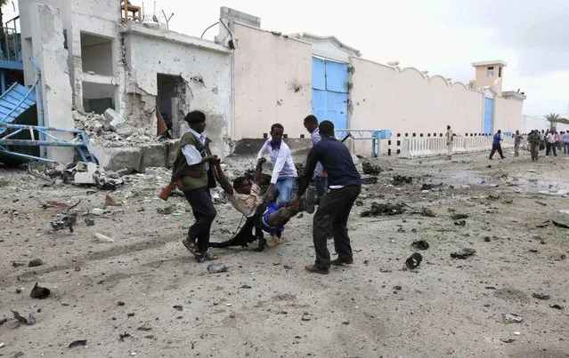 Somali government soldiers evacuate an injured man after a suicide bomb attack inside the United Nations compound in the Somali capital Mogadishu, June 19, 2013. A suicide bomber and several gunmen attacked a United Nations compound in the Somali capital Mogadishu on Wednesday, police and witnesses said, in a strike that bore the hallmarks of al Qaeda-linked militants. (Photo by Omar Faruk/Reuters)