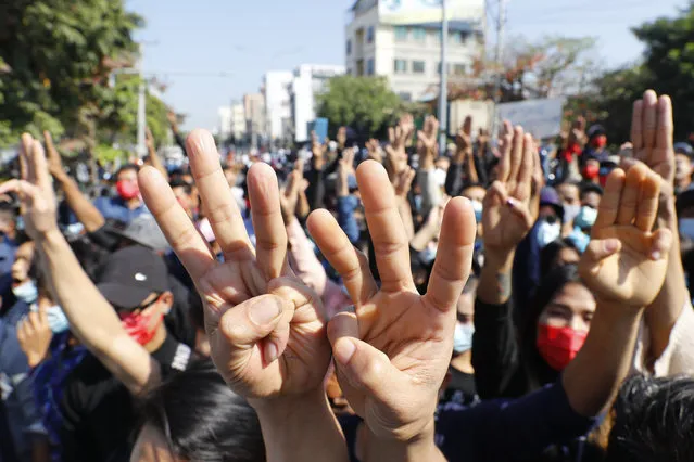 Protesters flash the three-fingered salute, a symbol of resistance, during a protest in Mandalay, Myanmar, Tuesday, February 9, 2021. Protesters continued to gather Tuesday morning in major cities breaching Myanmar's new military rulers ban of public gathering of five or more issued on Monday intended to crack down on peaceful public protests opposing their takeover. (Photo by AP Photo/Stringer)