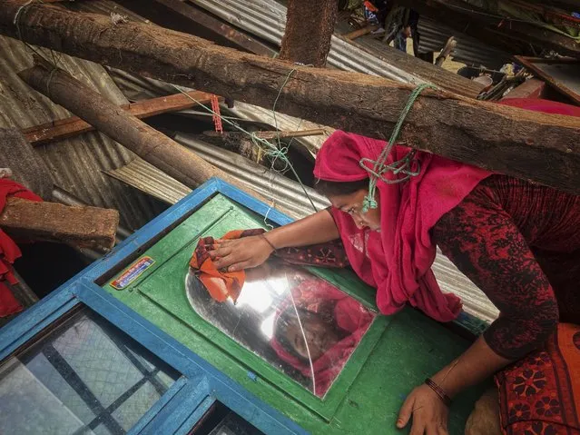 A woman salvages belongings from her home damaged by Cyclone Mocha at Saint Martin island in Cox's Bazar, Bangladesh, Monday, May 15, 2023. (Photo by Al-emrun Garjon/AP Photo)