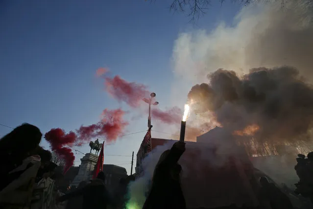 Students light flares as they stage a demonstration against war and to remember the victims of 1969's Piazza Fontana's bombing, in Milan, Italy, Friday, December 11, 2015. (Photo by Luca Bruno/AP Photo)