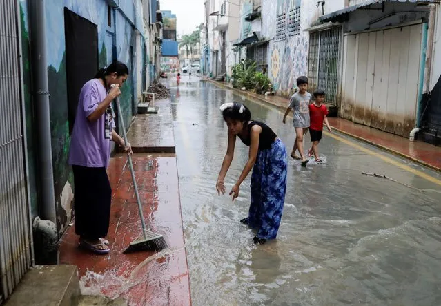 People clean the back-alley of shophouse as the floodwaters recede, in Kota Tinggi, Johor, Malaysia on March 5, 2023. (Photo by Hasnoor Hussain/Reuters)
