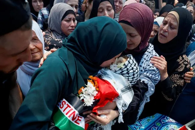 The mother of three-year-old Palestinian boy Mohammad al-Tamimi, who died of his wounds after being shot by Israeli forces, carries his body during his funeral near Ramallah in the Israeli-occupied West Bank on June 6, 2023. (Photo by Mohammed Torokman/Reuters)