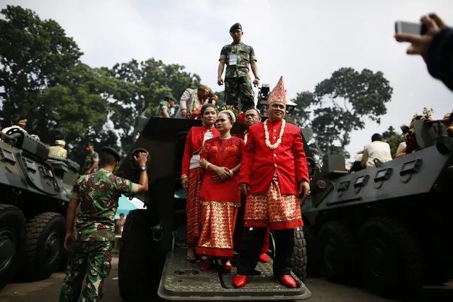 Indonesian couples disembark an Army's Anoa armored personnel carrier (APC) during a mass wedding ceremony in Jakarta, Indonesia, 28 January 2015. More than 5000 couples participated on a mass wedding ceremony to legalized the previous religious marriage ceremonies. Most of the couples have not officially registered their marriage for economic reasons as it cost up to 500,000 IDR (35 euro) to legalized a marriage. The ceremony organized by Rajawali Foundation. (Photo by Mast Irham/EPA)
