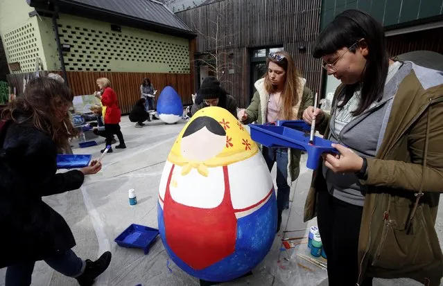 Painters and students paint huge Easter eggs at Zagreb's Zoo on March 16, 2021. More than ten 125 centimetres high Easter eggs will be installed around the Zoo garden. Zagreb's Zoo organised performances during the announcement of the Spring festival as a part of Easter customs in Croatia. (Photo by Denis Lovrovic/AFP Photo)