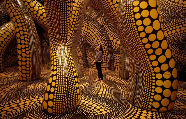 A visitor walks through a part of Japanese artist Yayoi Kusama's installation “You, Me and The Balloons” during a preview ahead of the start of the Manchester International Festival in Manchester, Britain on June 29, 2023. (Photo by Phil Noble/Reuters)
