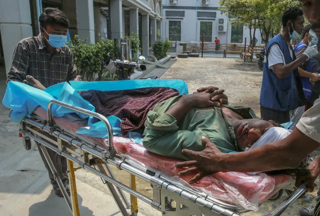 People push a stretcher with body of a man who a doctor said was shot and killed Tuesday, March 23, 2021, by Myanmar security forces during anti coup protest in Mandalay, Myanmar. Opposition against the Feb 1 military coup continues in Myanmar. The civil disobedience movement has used widespread boycotts, strikes and other actions to demand that power be returned to the elected government led by Aung San Suu Kyi. (Photo by AP Photo/Stringer)