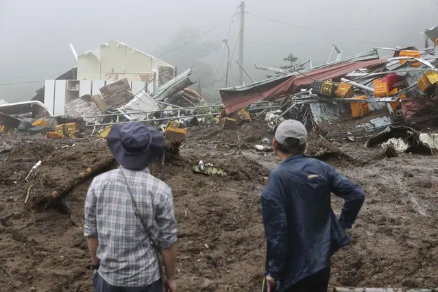 People watch their collapsed houses after a landslide caused by heavy rain in Yecheon, South Korea, Sunday, July 16, 2023. Days of heavy rain triggered flash floods and landslides and destroyed homes, leaving scores of people dead and forcing thousands to evacuate, officials said Sunday. (Photo by Yun Kwan-shick/Yonhap via AP Photo)