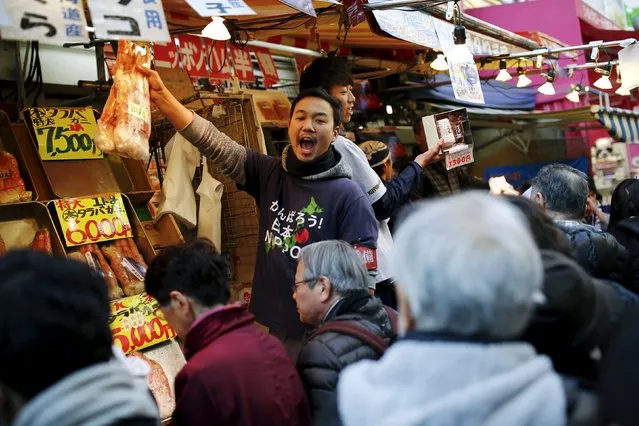 Fishmongers offer their goods for sale as people crowd Ameyoko market to shop for food and goods ahead of the New Year holidays in Tokyo, Japan, December 30, 2015. (Photo by Thomas Peter/Reuters)