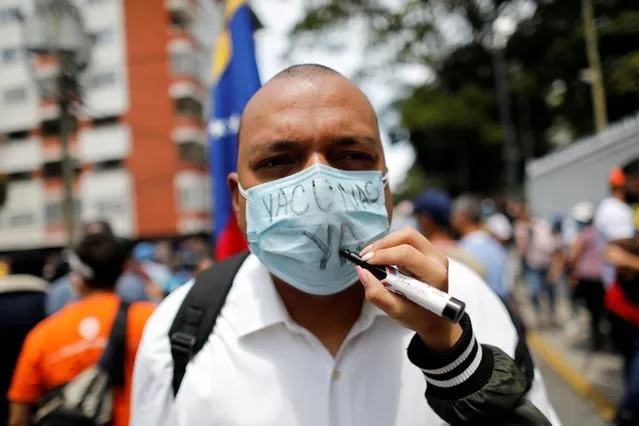 A person writes “Vaccines, now!” on the face mask of a healthcare worker during a protest to demand that all people get vaccinated against the coronavirus disease (COVID-19), in Caracas, Venezuela on April 17, 2021. (Photo by Leonardo Fernandez Viloria/Reuters)