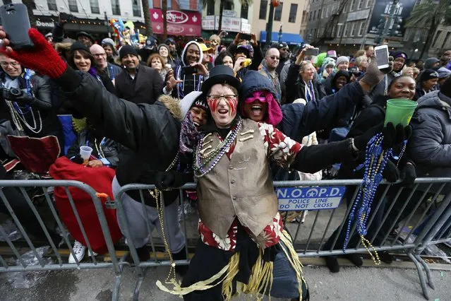 A member of the Mondo Kayo Social and Marching Club dances with parade goers on Mardi Gras in New Orleans, Louisiana February 17, 2015. (Photo by Jonathan Bachman/Reuters)
