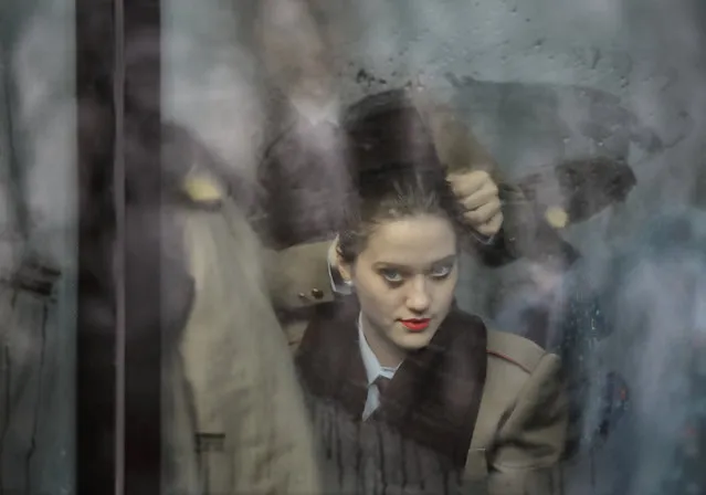 A Romanian military medical student gets her hair set up by a colleague, while sitting on a bus behind steamy windows, before the National Day parade in Bucharest, Romania, Thursday, December 1, 2016. Military planes and helicopters flew over the Romanian capital Thursday as thousands turned out to celebrate the national day, marking the date when the country reunified with Transylvania in 1918. (Photo by Vadim Ghirda/AP Photo)