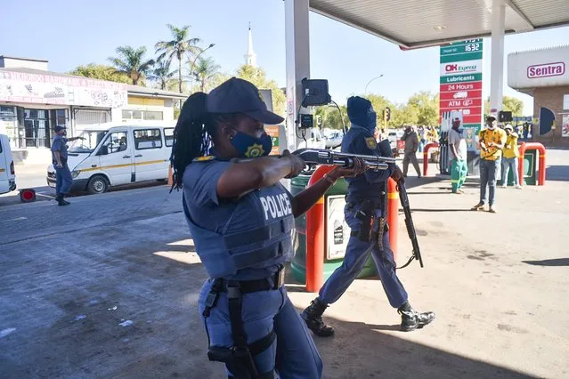 A Police officer reacts to protestors outside the Piet Retief Magistrates court where the five accused in the shooting of the Coka brothers on the Pampoenkraal farm appeared, Mhkondo, Mpumalanga, South Africa on April 19, 2021. (Photo by Jacques Nelles)