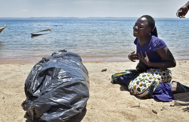 A woman cries beside the body of her sister, a victim of the MV Nyerere passenger ferry, as she awaits transportation for burial on Ukara Island, Tanzania Saturday, September 22, 2018. The death toll soared past 200 on Saturday while officials said a survivor was found inside the capsized ferry and search efforts were ending to focus on identifying bodies, two days after the Lake Victoria disaster. (Photo by Andrew Kasuku/AP Photo)