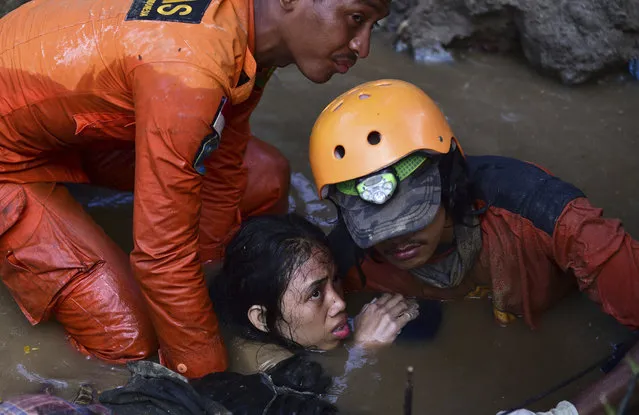 Rescuers evacuate an earthquake survivor by a damaged house following earthquakes and tsunami in Palu, Central Sulawesi, Indonesia, Sunday, September 30, 2018. Rescuers were scrambling Sunday to try to find trapped victims in collapsed buildings where voices could be heard screaming for help after a massive earthquake in Indonesia spawned a deadly tsunami two days ago. (Photo by Arimacs Wilander/AP Photo)