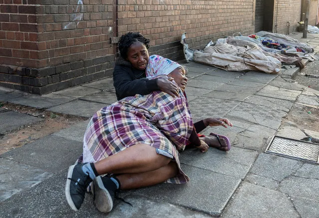 Women react after a deadly blaze in the early hours of the morning, in Johannesburg, South Africa on August 31, 2023. (Photo by Shiraaz Mohamed/Reuters)